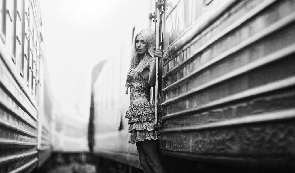 Модель стоит у входа в вагон, черно белое фото