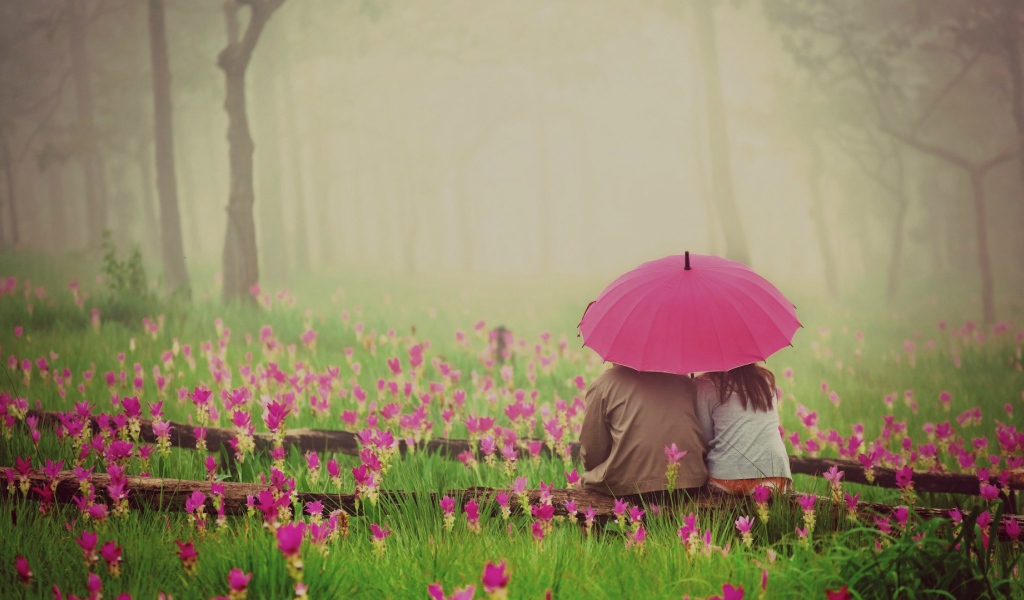 Двое сидят под зонтом