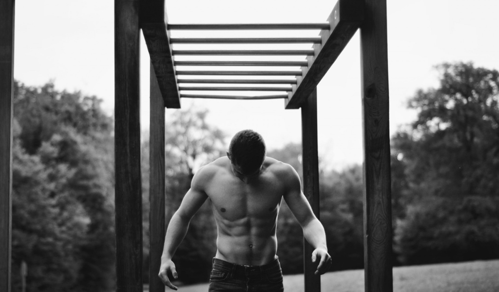 Мужчина занимается спортом на турнике