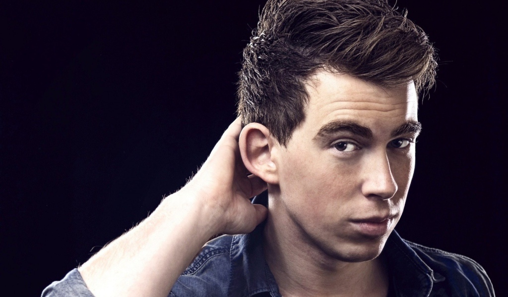 Молодой парень чешет затылок