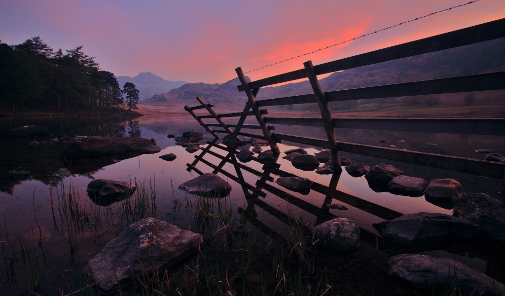 Полуразрушенный забор у воды