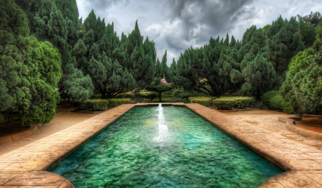 Пруд с фонтанами в саду