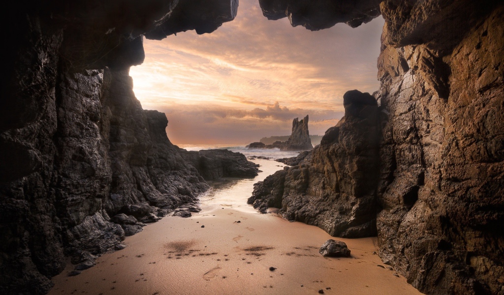 Мокрый песок у входа в пещеру