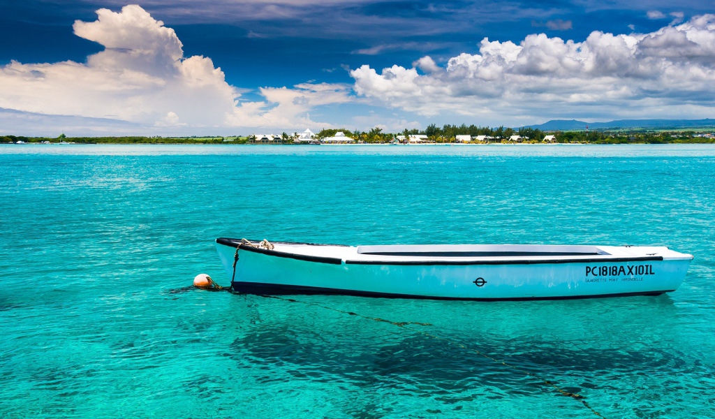 Белая лодка на голубой прозрачной воде
