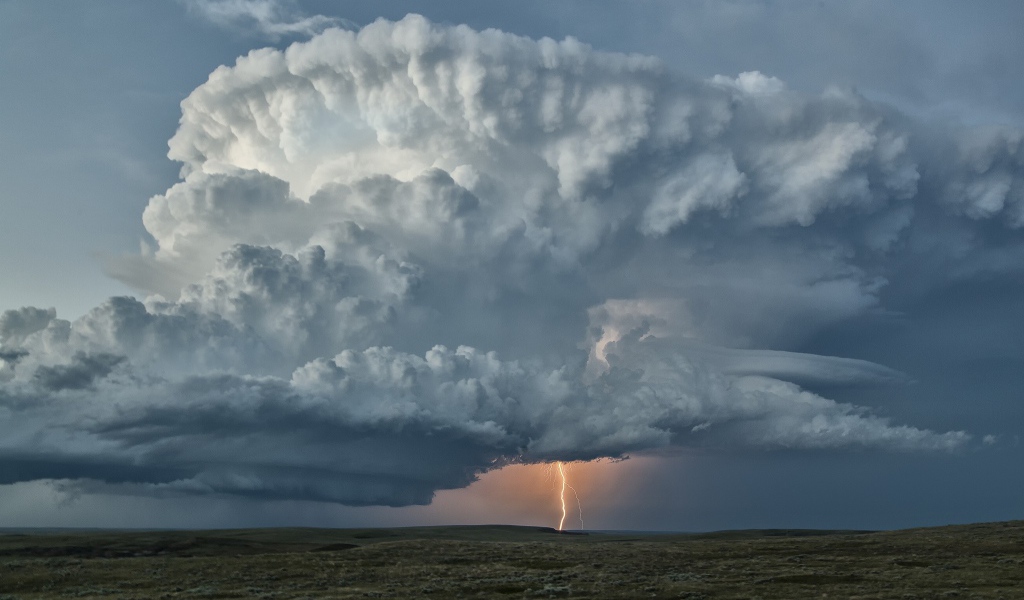 Оранжевая молния в огромном белом облаке