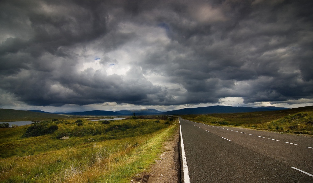 Шоссе среди полей под мрачными облаками