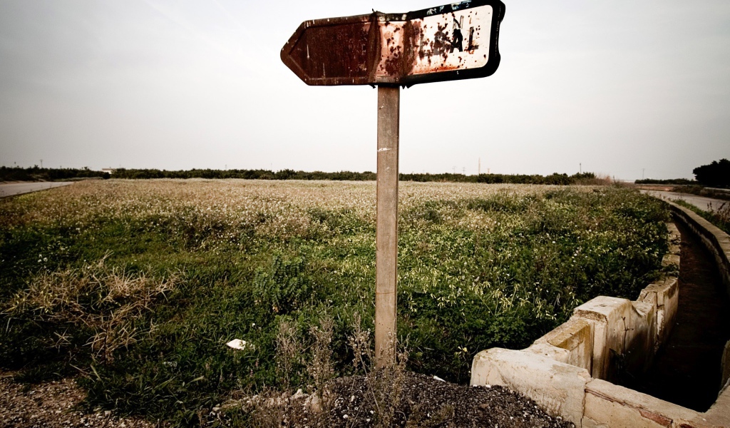 Ржавый указатель направления у поля