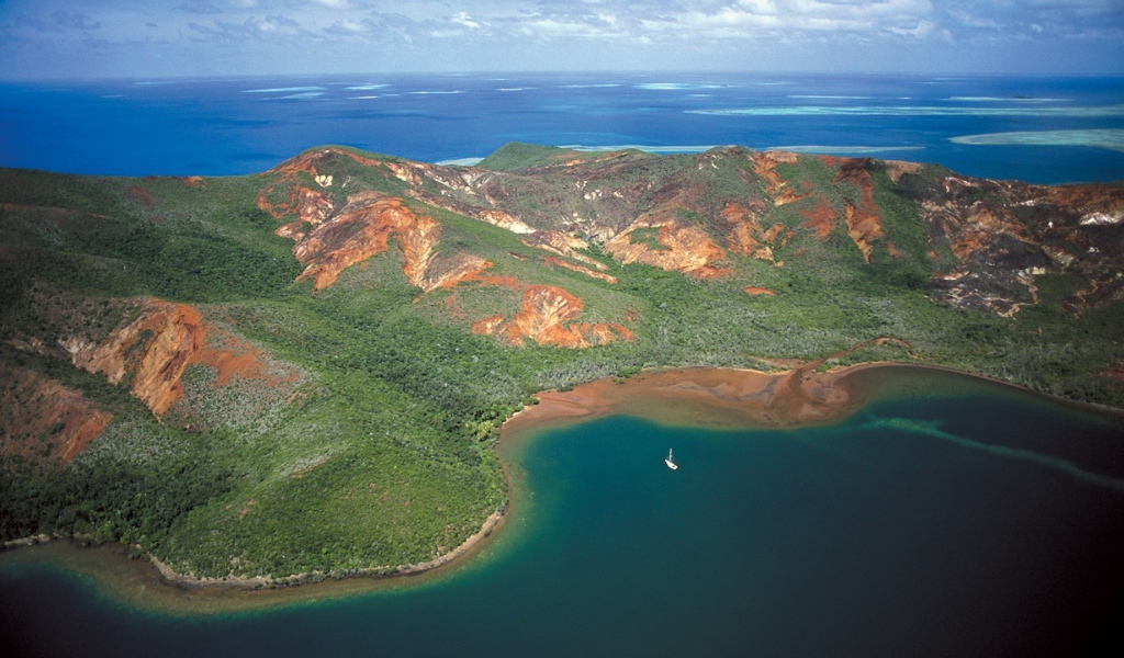 Белая лодка у необитаемого лесистого острова