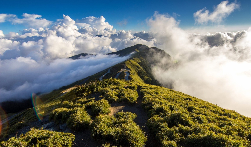 Зеленый горный хребет среди облаков