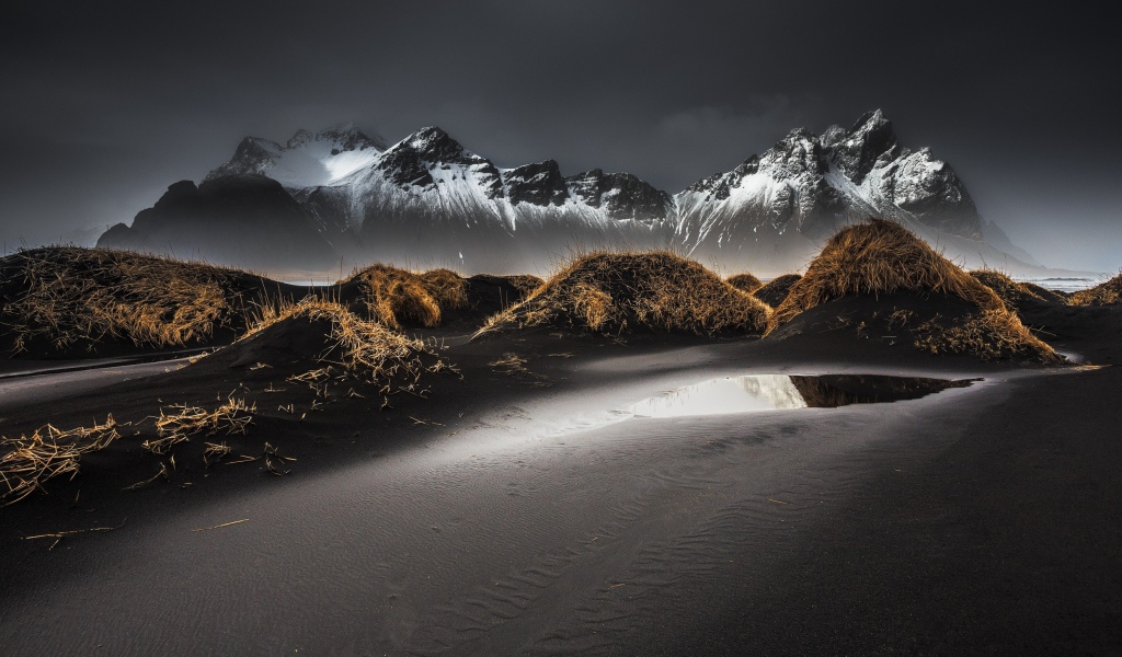 Серый песок на фоне гор