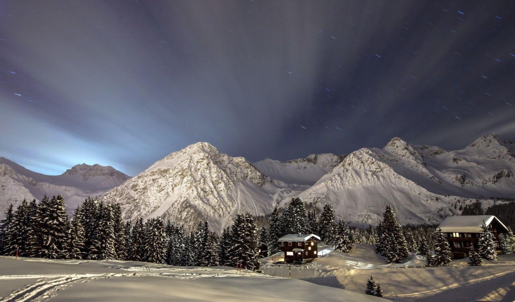 Лучи света над заснеженными горами