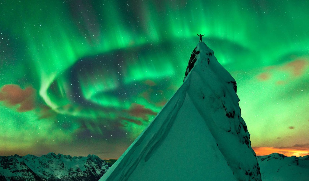 Snowy peak in the background of the Northern Lights