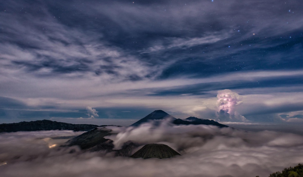 Звездное небо над облаками и туманом в горах