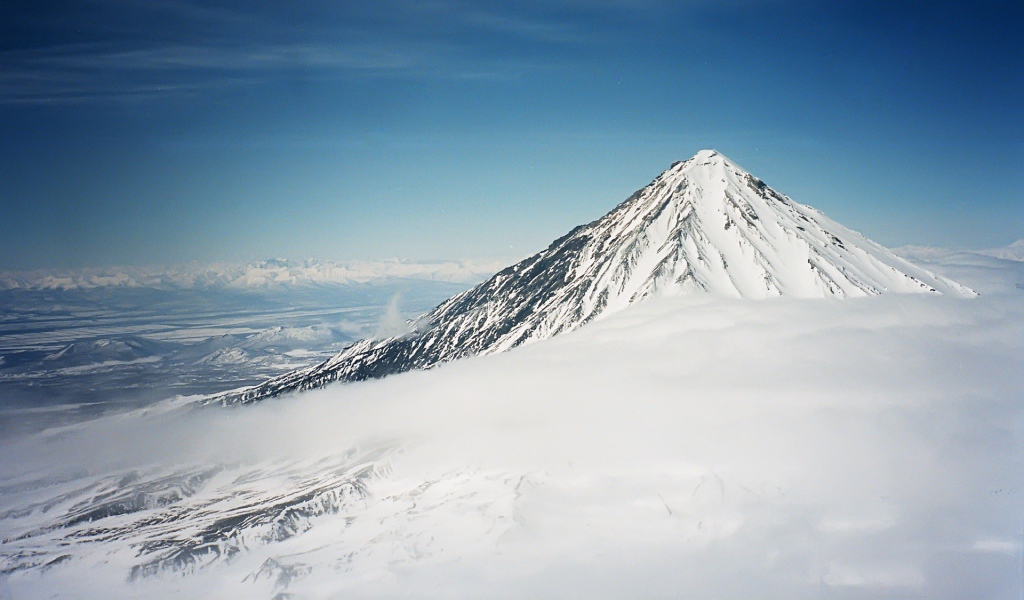 Вершина покрытой снегом горы в облаке