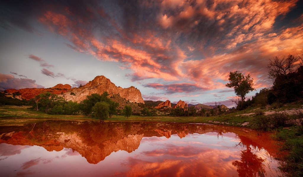 Облака отражаются в коричневой воде озера