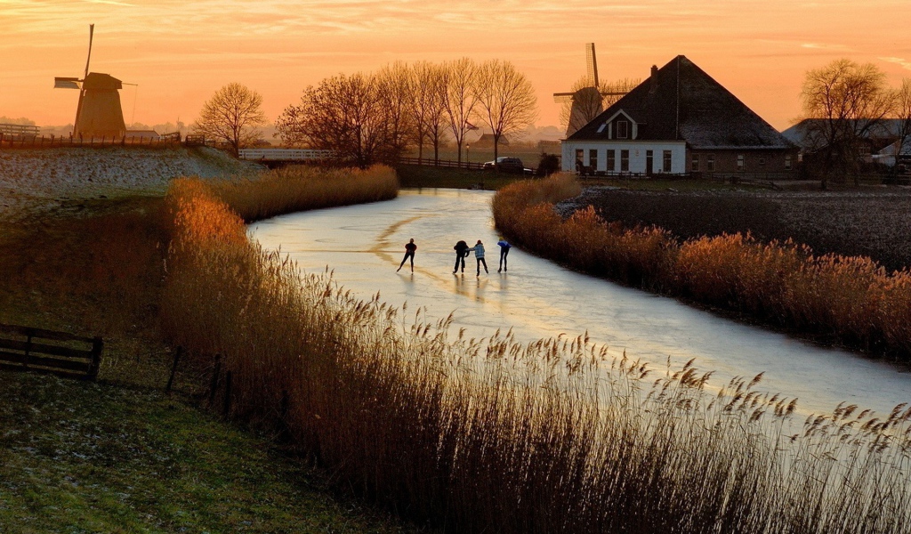 Дети катаются на коньках по замерзшей реке в Нидерландах
