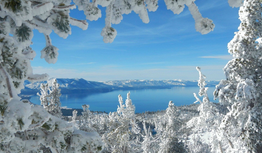 Горное озеро в рамке из заснеженных ветвей