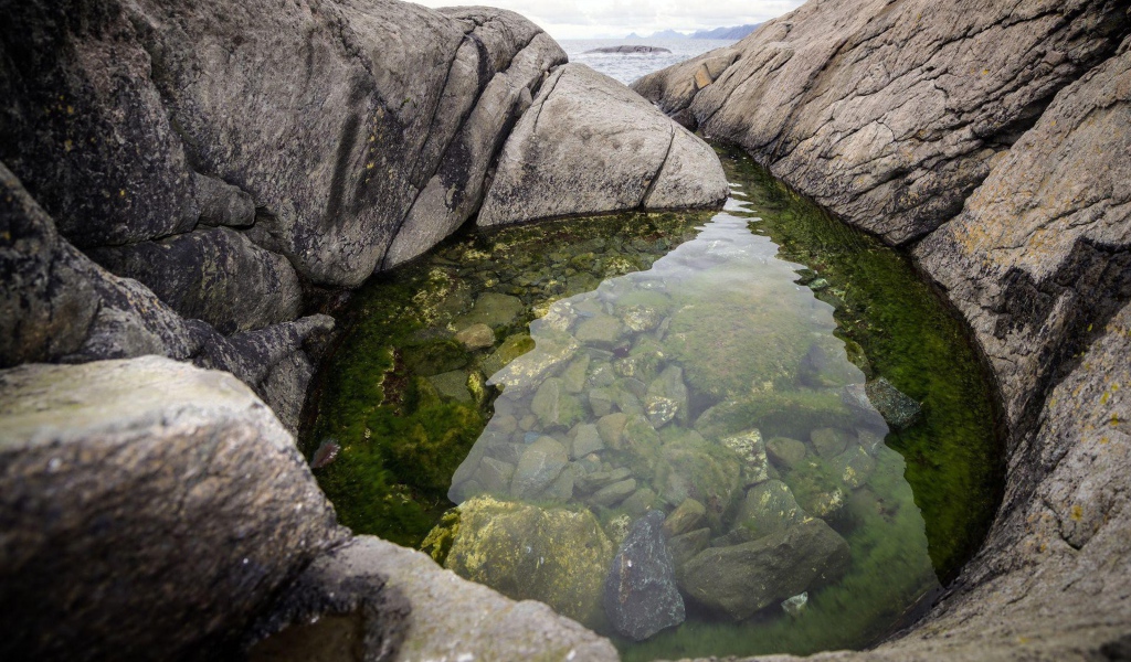 A small lake in the rocks near the shore