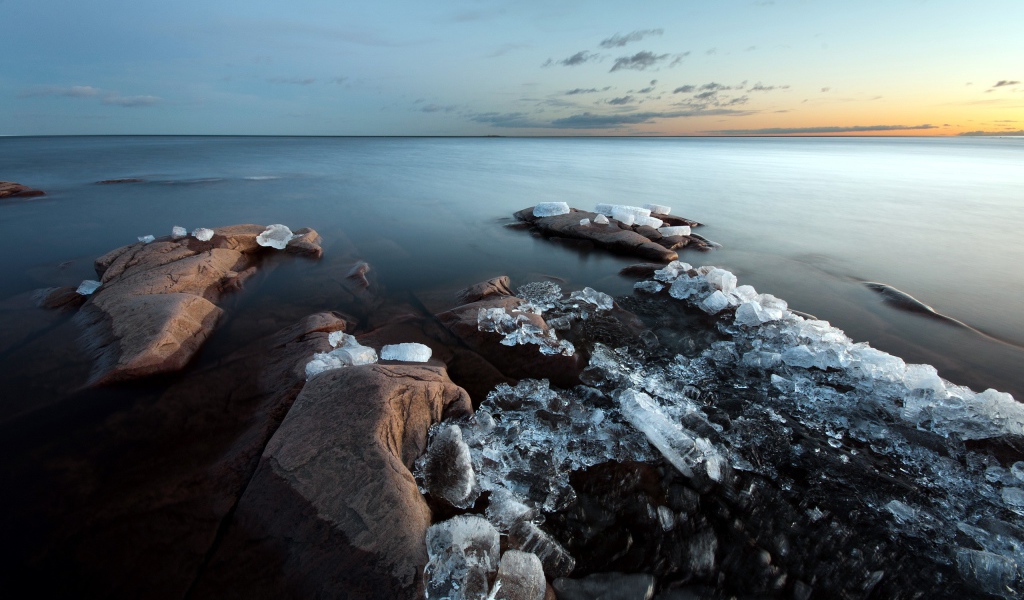 Куски льда на камнях у берега