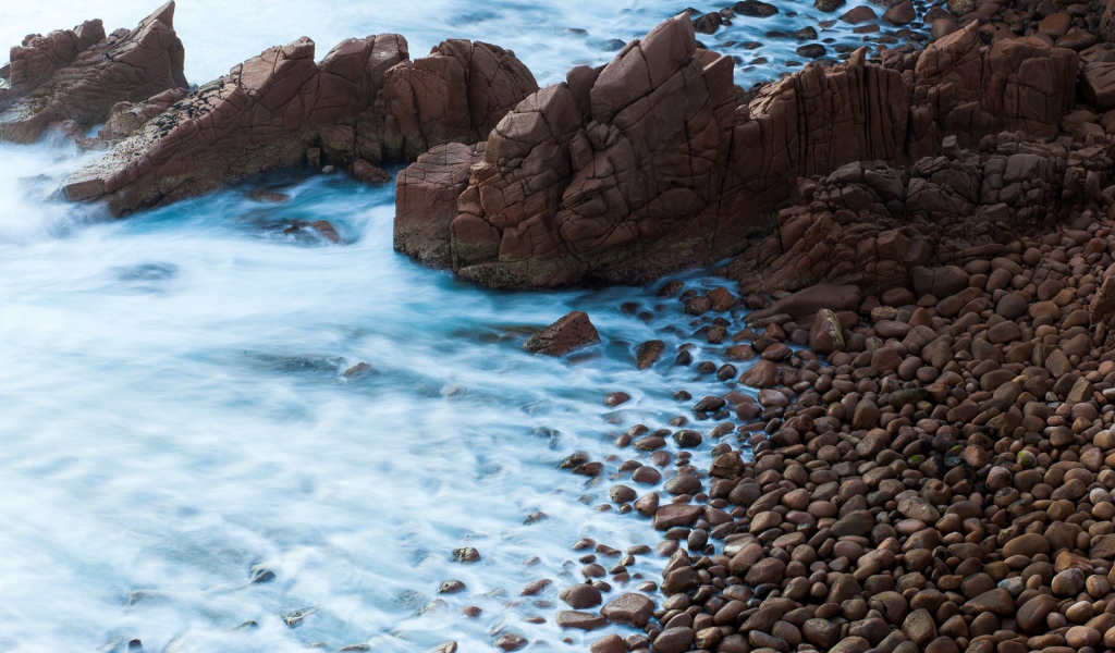 Мелкие коричневые камни на берегу моря