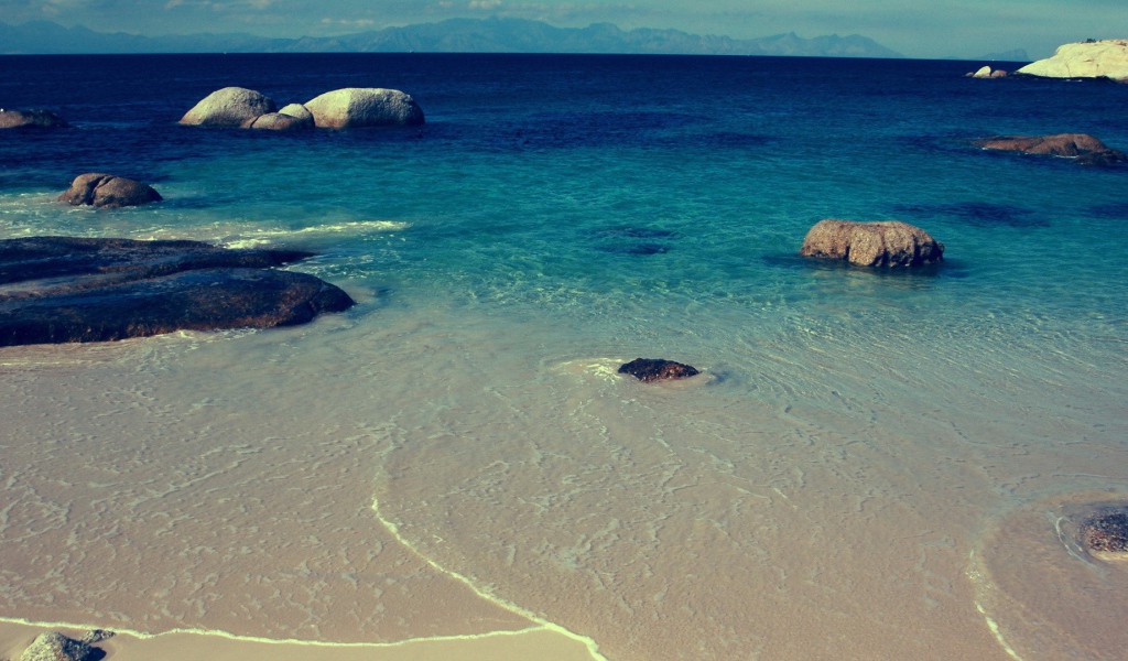 Камни в синей воде у берега моря