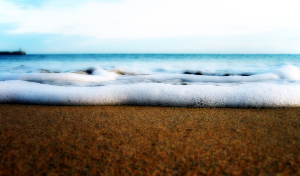 Белая пена волны у берега