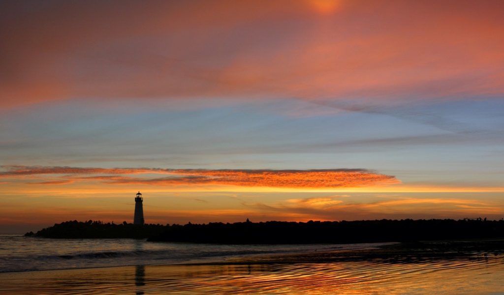 Силуэт маяка на фоне оранжевых облаков