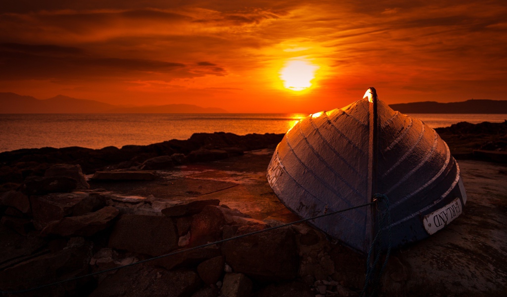 Перевернутая лодка на фоне заката