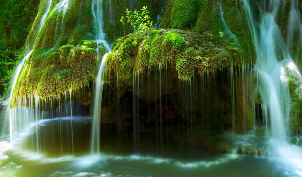 Вода стекает по покрытым мхом скалам