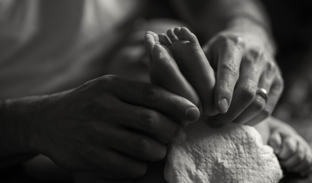 Ступни ребенка в руках отца