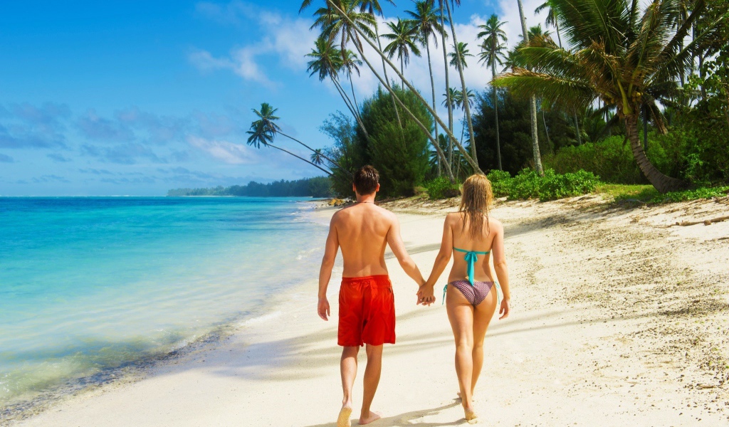 Парень и девушка идут по пляжу