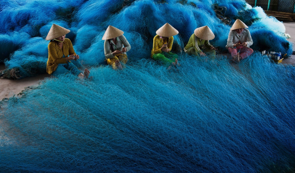 Vietnamese women weave fishing nets