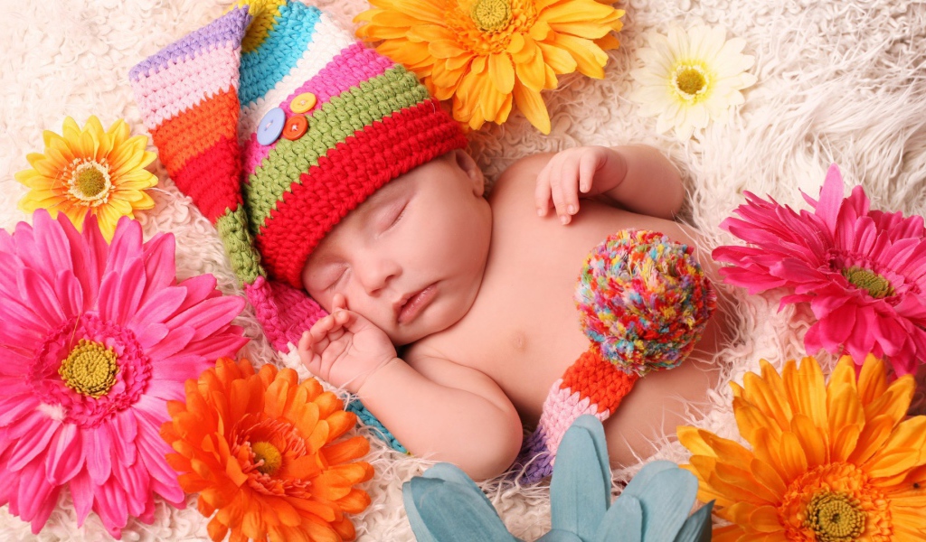 Малыш спит в постели среди цветов