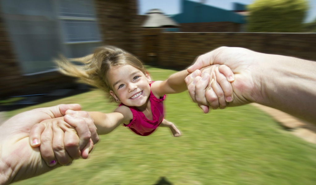 Веселая девочка в руках отца