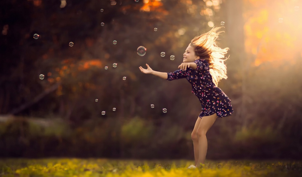 Девочка играет с мыльными пузырями