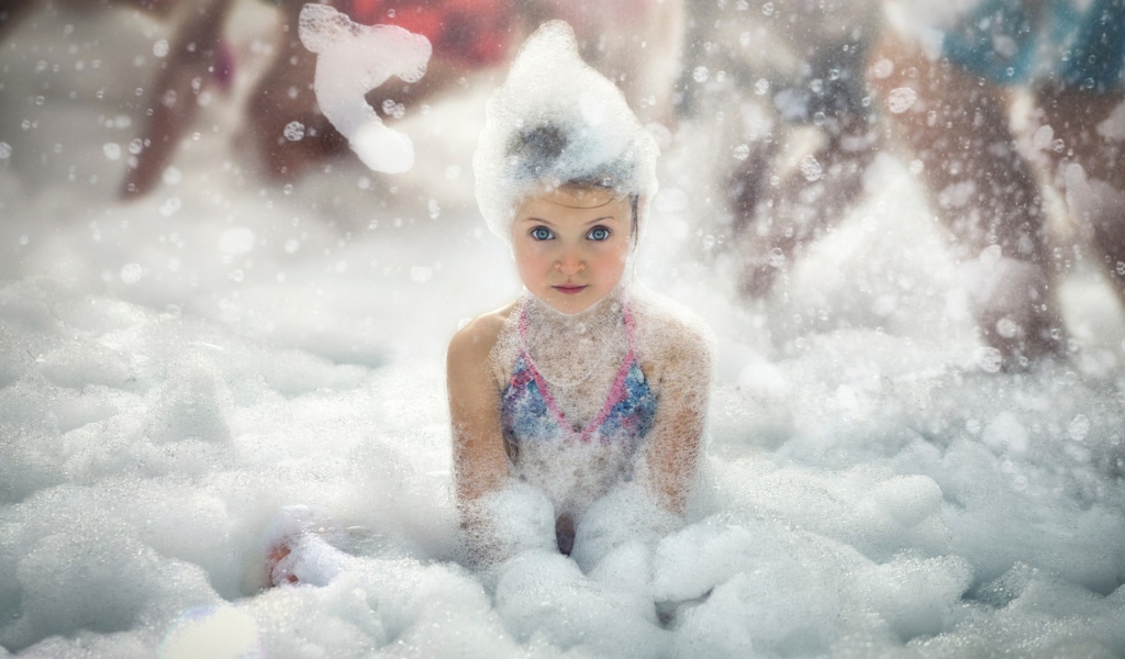 Девочка играет в пене