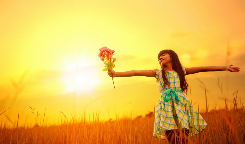 Девочка с букетом стоит в поле