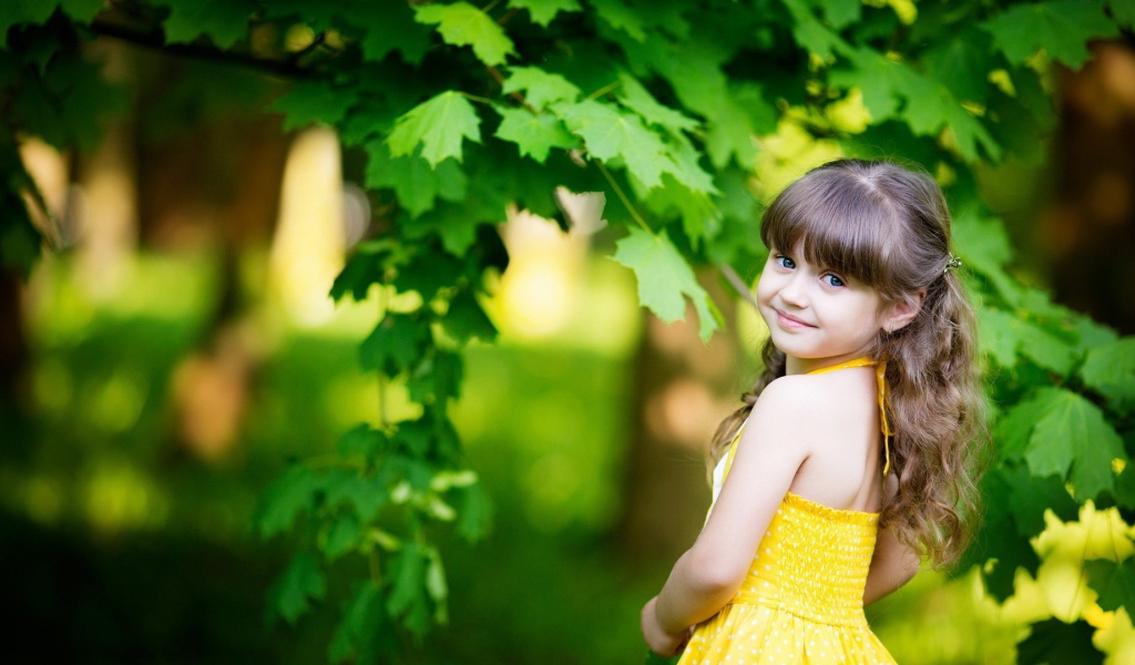 Маленькая девочка у зеленого клена