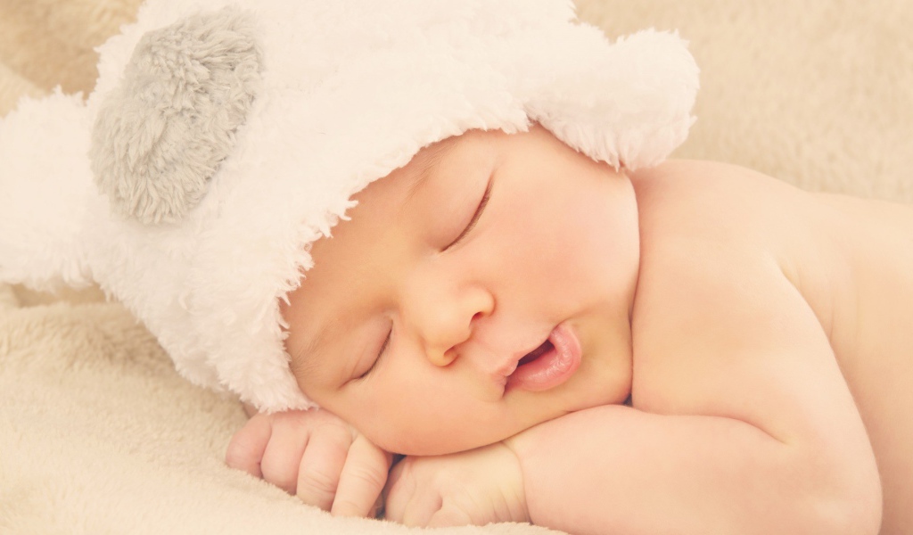 Спящий ребенок в белой шапке