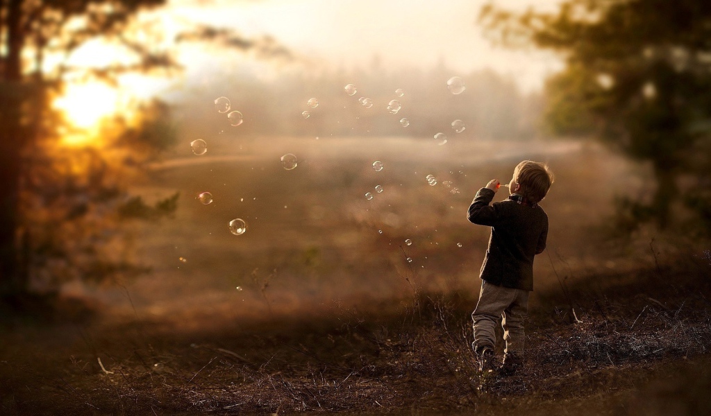 Мальчик запускает мыльные пузыри