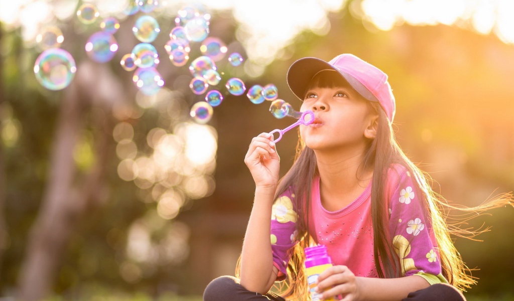 Девочка запускает мыльные пузыри