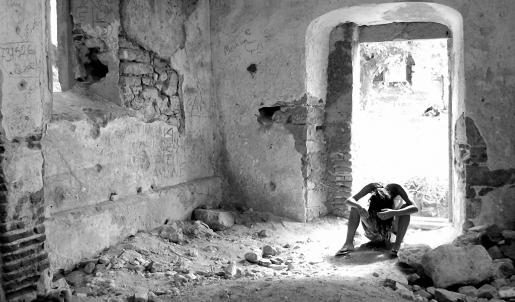 Человек на развалинах дома