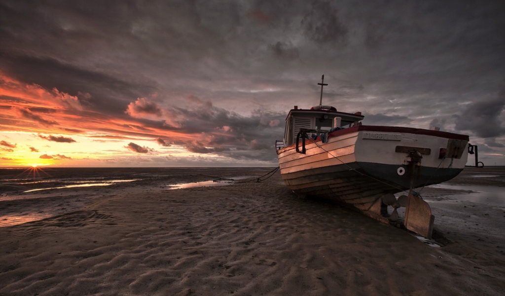 Лодка на песке пляжа во время отлива