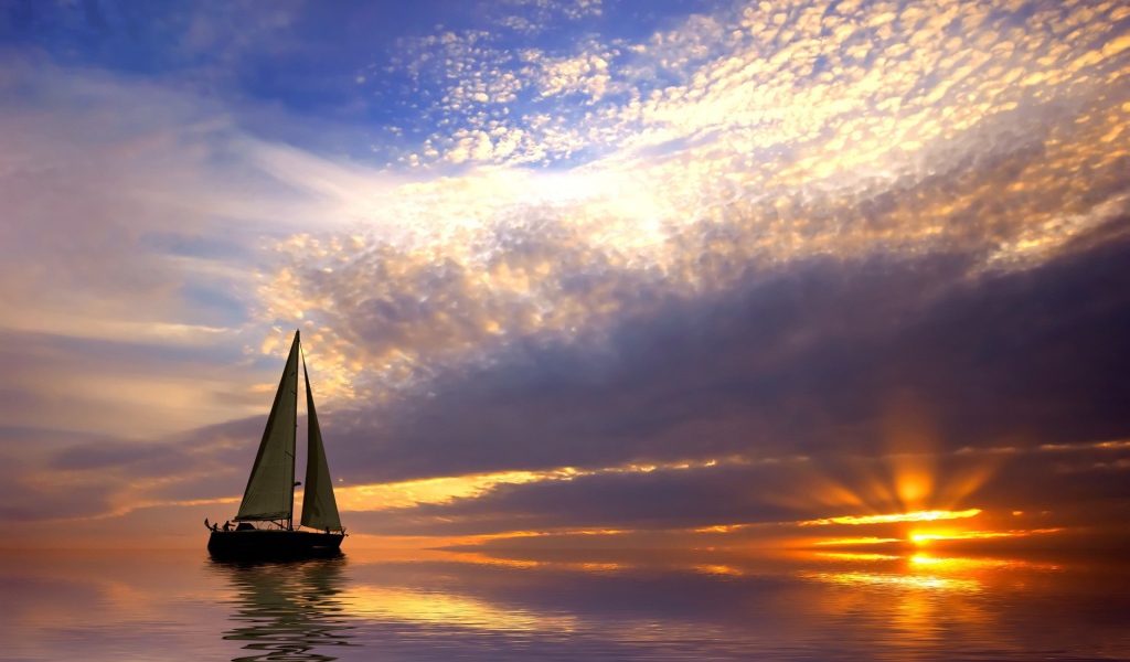 Парусная лодка в спокойном море на закате