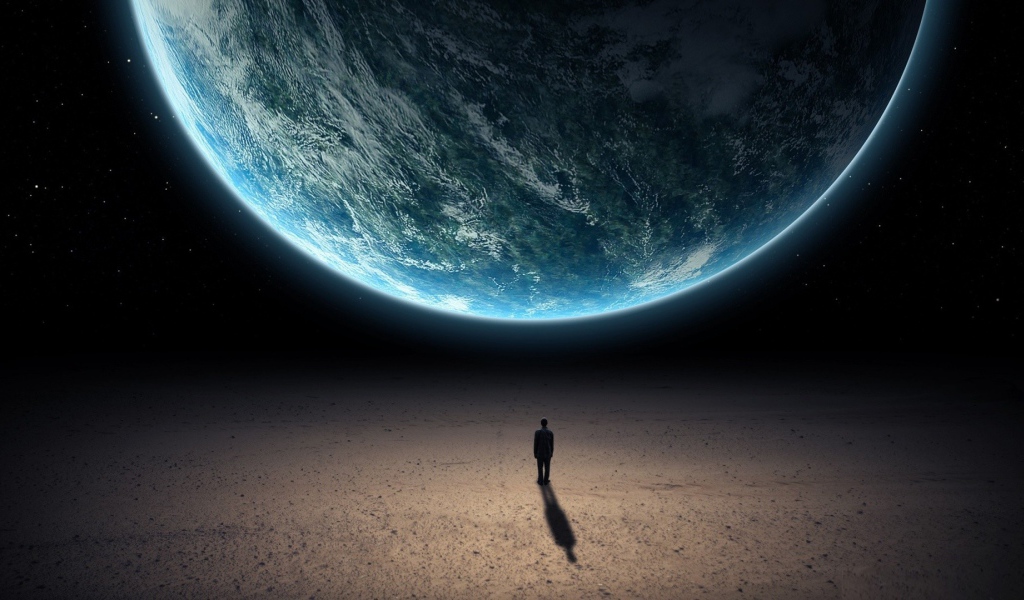 Человек стоит перед планетой