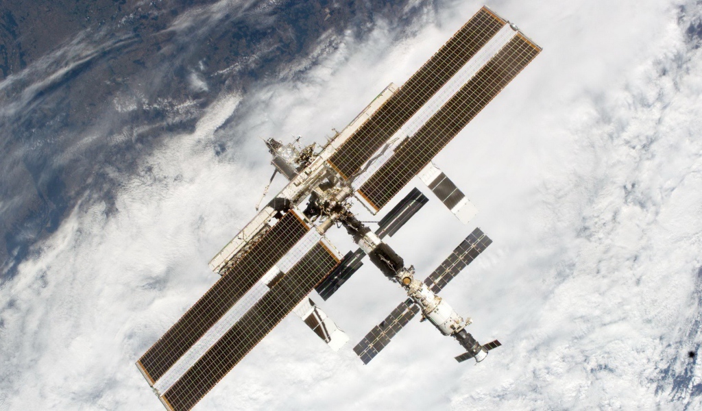 МКС пролетает над облаками на Земле