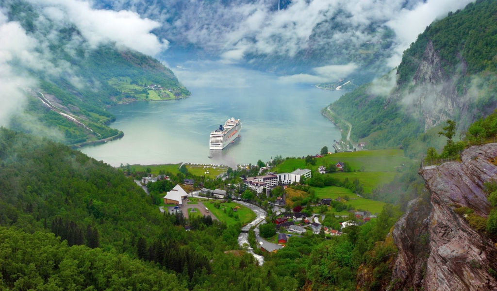 Круизный корабль у прибрежной деревушки в Норвегии