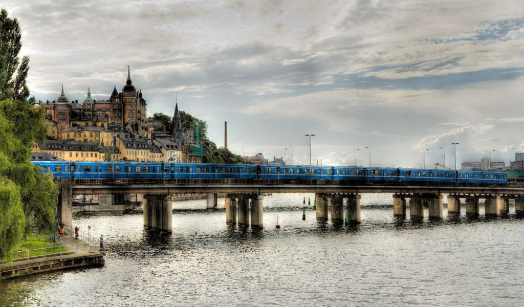 Поезд пересекает мост над рекой в Швеции