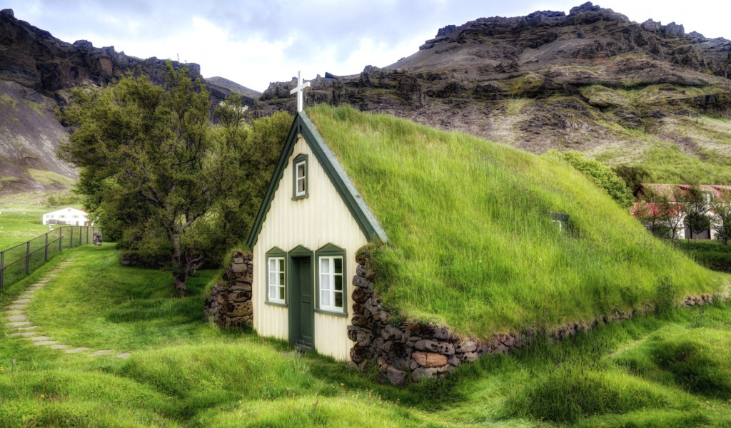 Поросшая травой крыша церкви в горной деревушке
