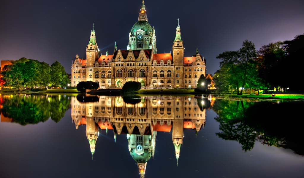 Освещенный замок с часами на башне